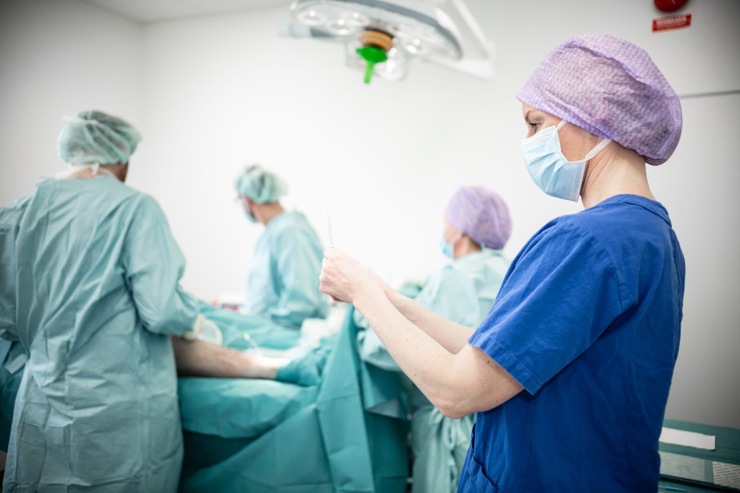 operationsrum med fyra personer som utför galloperation på patient.